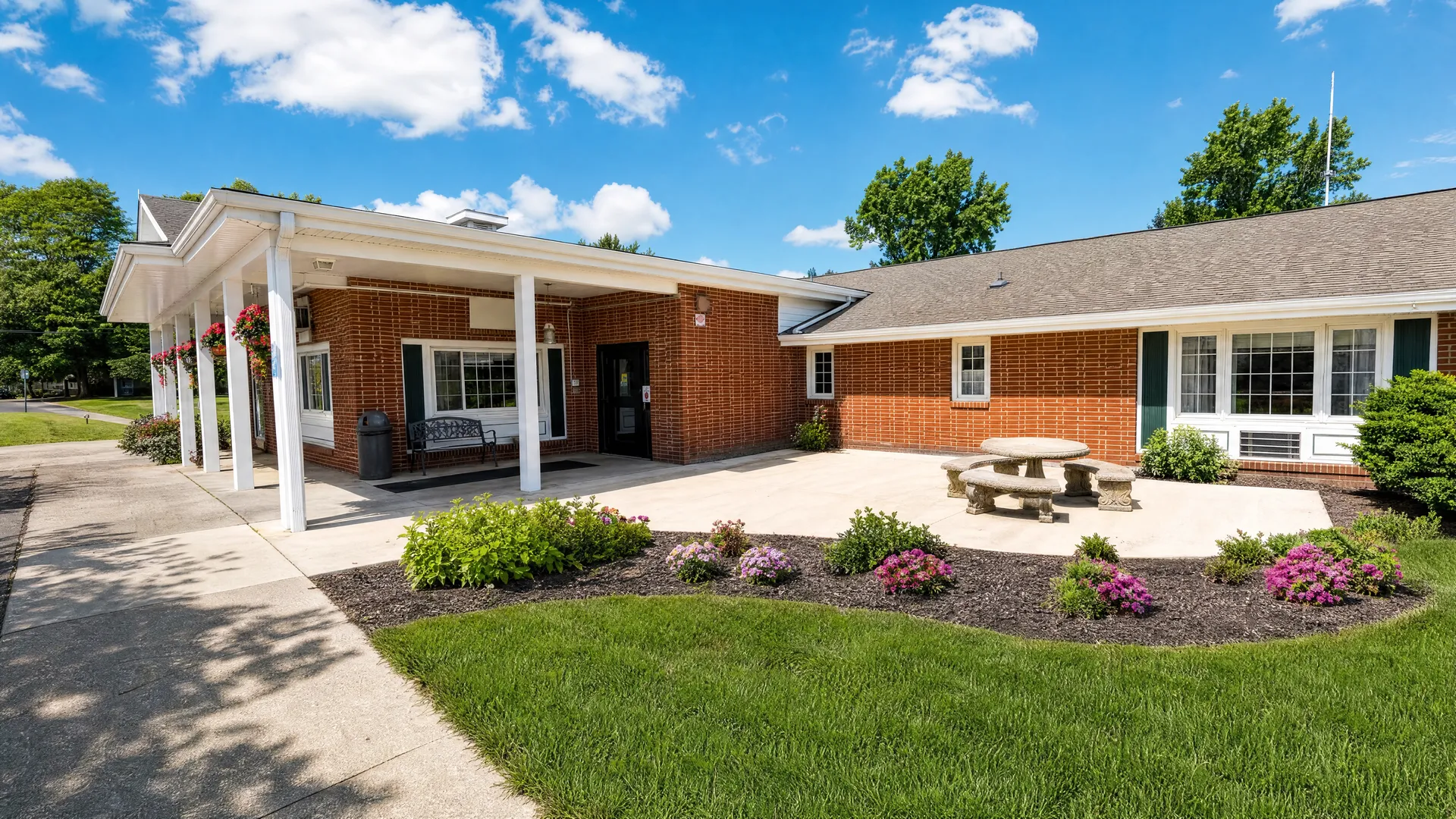 Exterior of Rehabilitation Center of Independence with a covered walkway, bench and picnic table