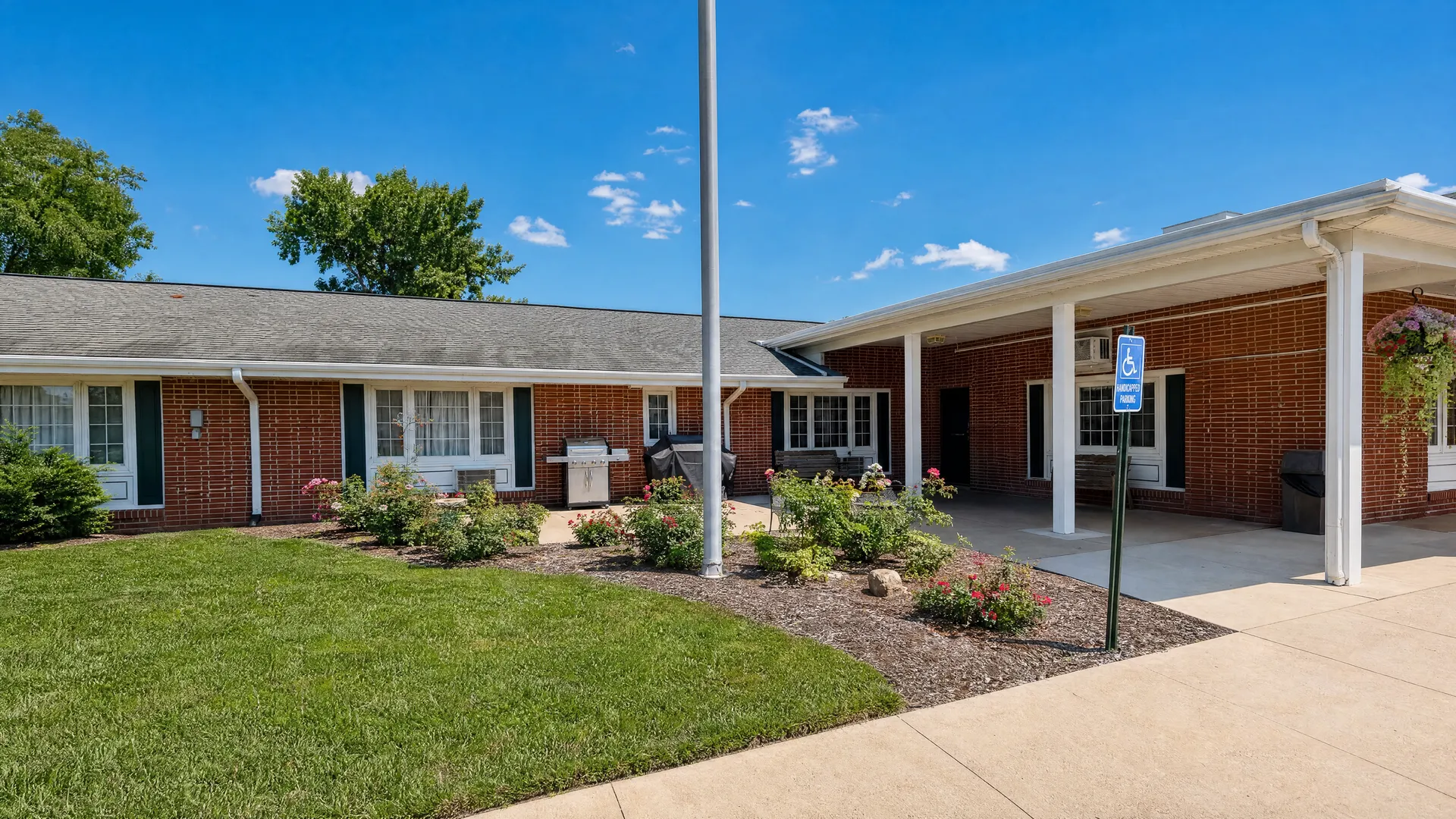 Entrance courtyard with a flag pole and covered drive-up at Rehabilitation Center of Independence