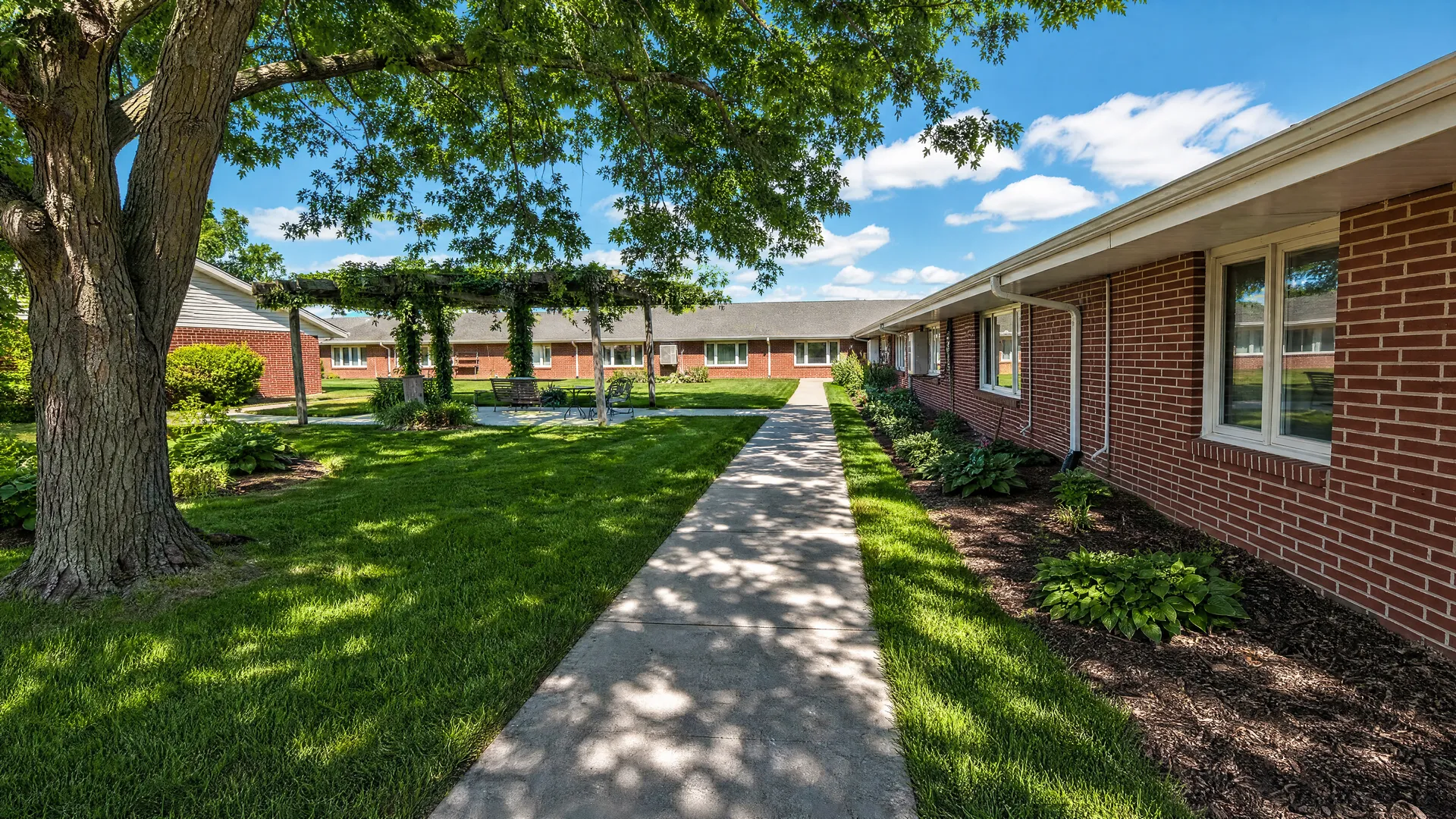 Shaded walkway with garden beds alongside Rehabilitation Center of Independence